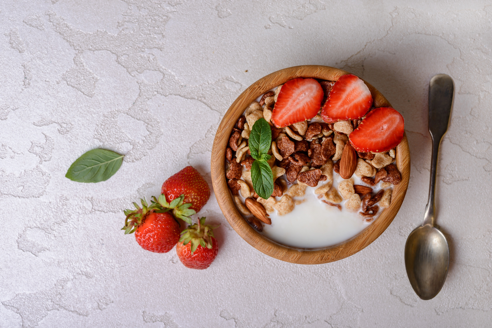 Healthy breakfast  with muesli,  berries and nuts  in bowl on grey background. Healthy food concept. Flat lay.